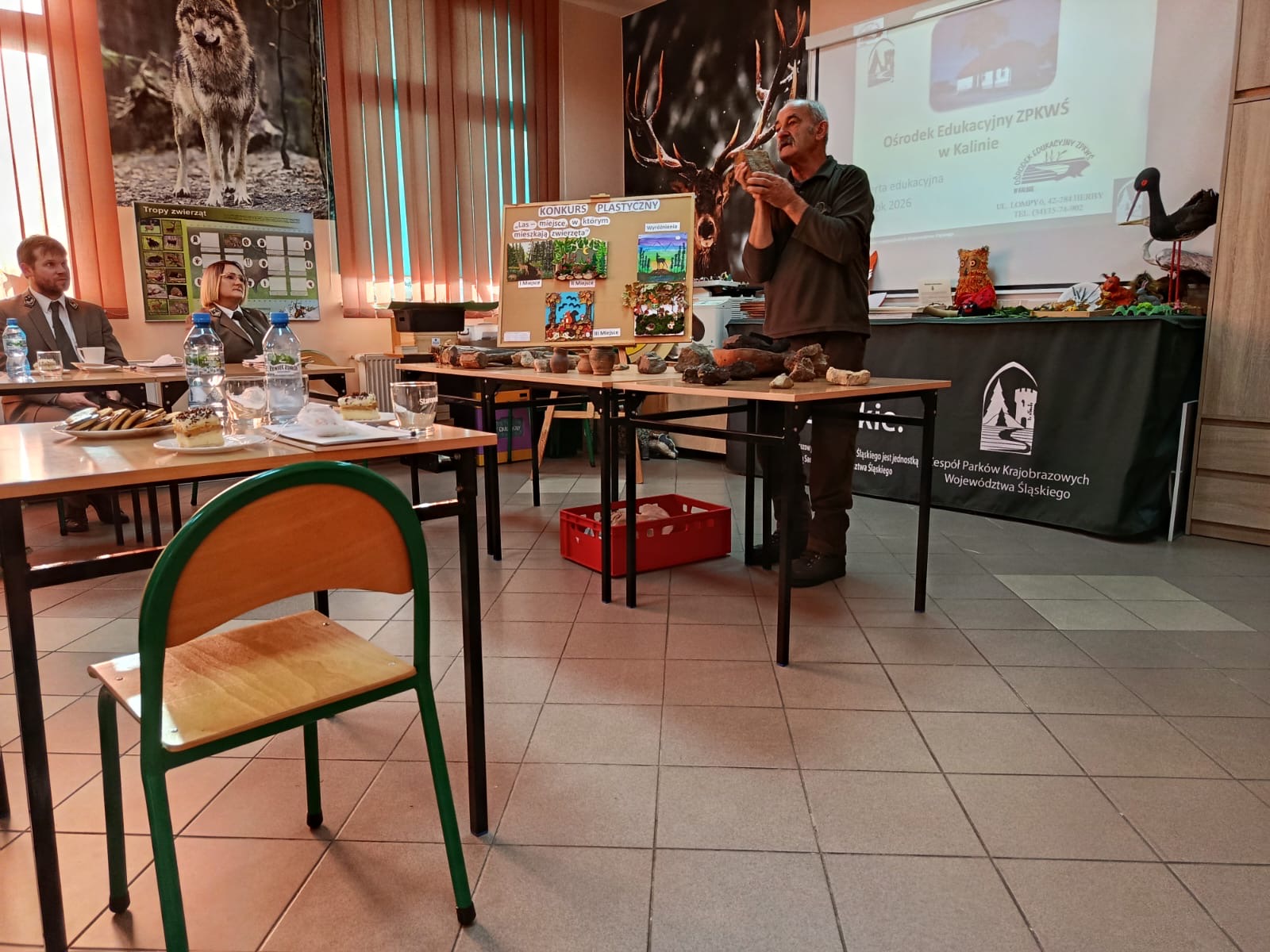 Osoba dorosła prowadzi wykład. w tle widoczna prezentacja multimedialna.