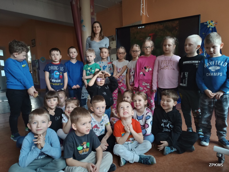 Grupa dzieci wraz z pracownikiem Parków Krajobrazowych pozuje do wspólnego zdjęcia 