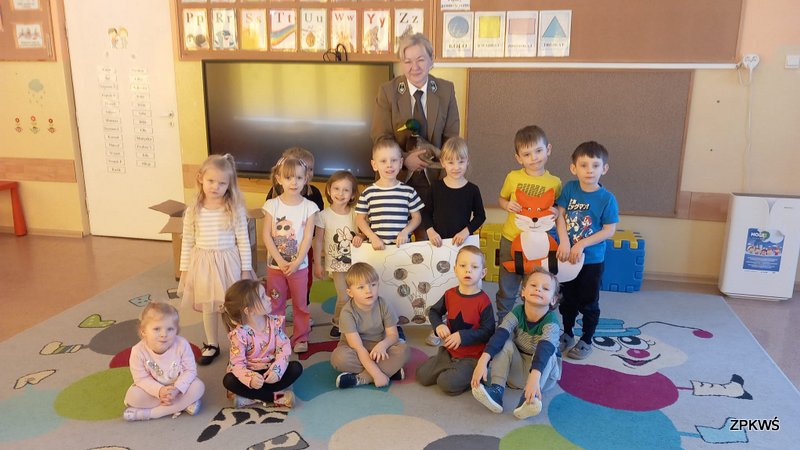 Kierownik Oddziału Biura ZPKWŚ w Kalinie wraz z grupą przedszkolaków trzymających w rękach plakat pozują do zdjęcia